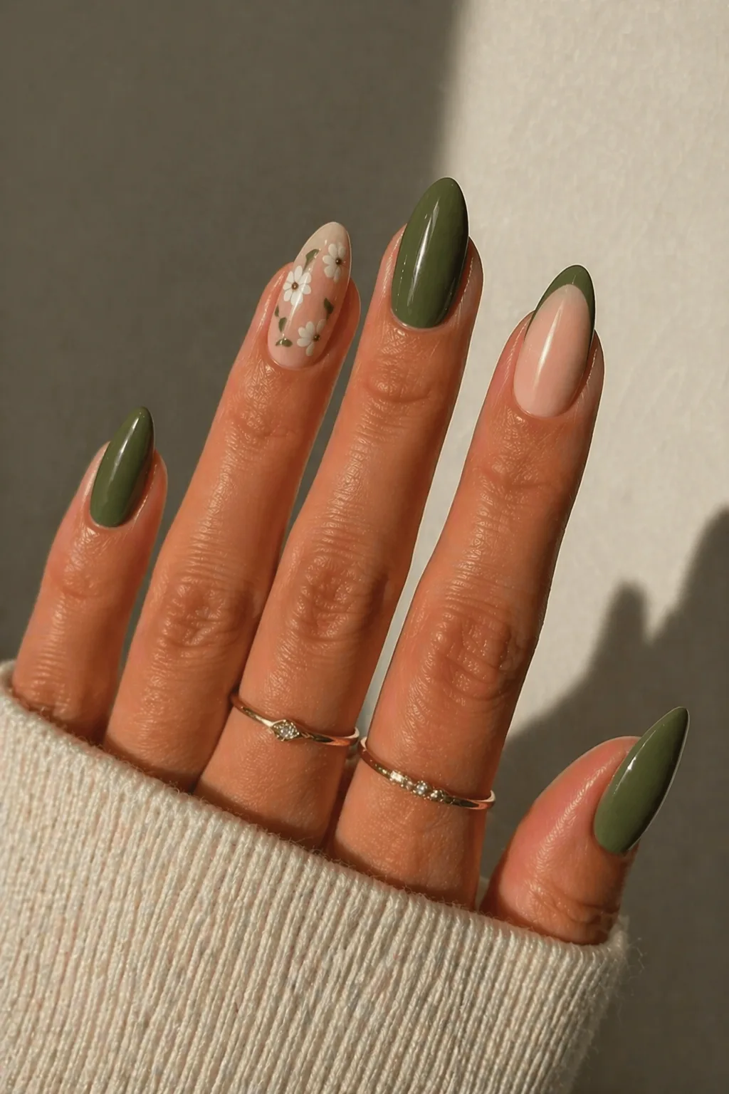 Ongles minimalistes vert olive avec art floral chic et bagues dorées, pour un look épuré et élégant au quotidien.