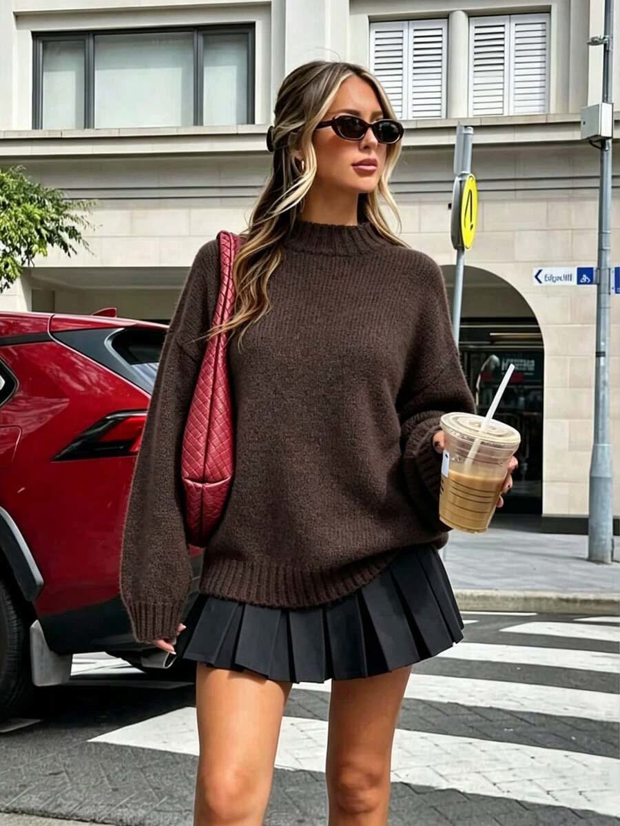 Hoodie marron oversize avec jupe plissée beige et baskets chunky.