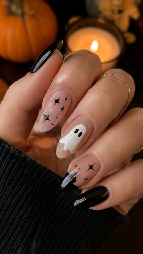 Manicure with black tips, ghost and star designs on nude nails.