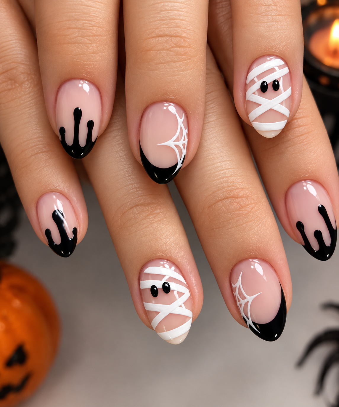 Nails with black drips, white spider webs, and mummy wraps.